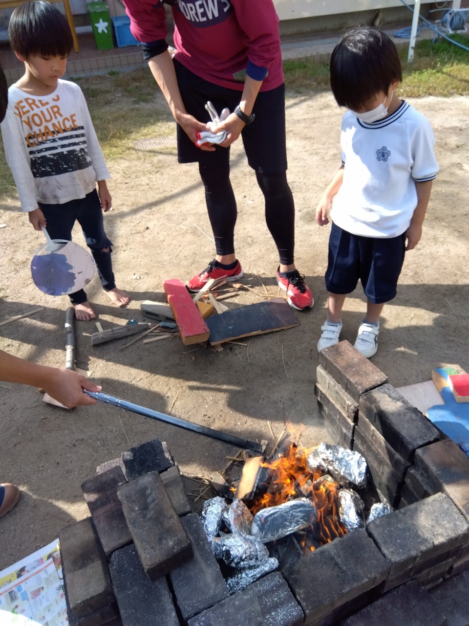 大阪市の遊び場にしなりジャガピーパークで焼き芋を作る小学生たち