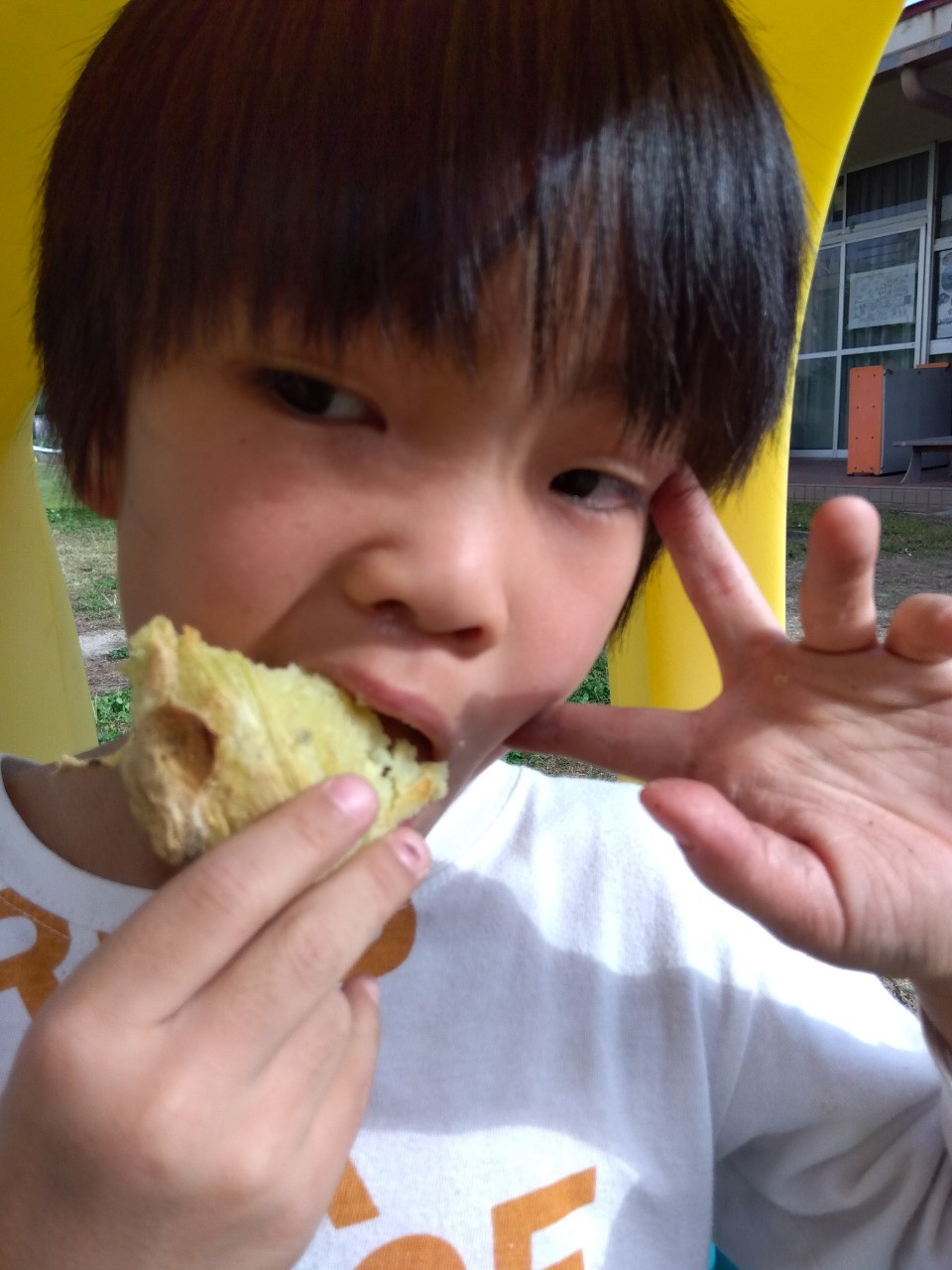 西成区津守のジャガピーパークで焼き芋を食べる男の子