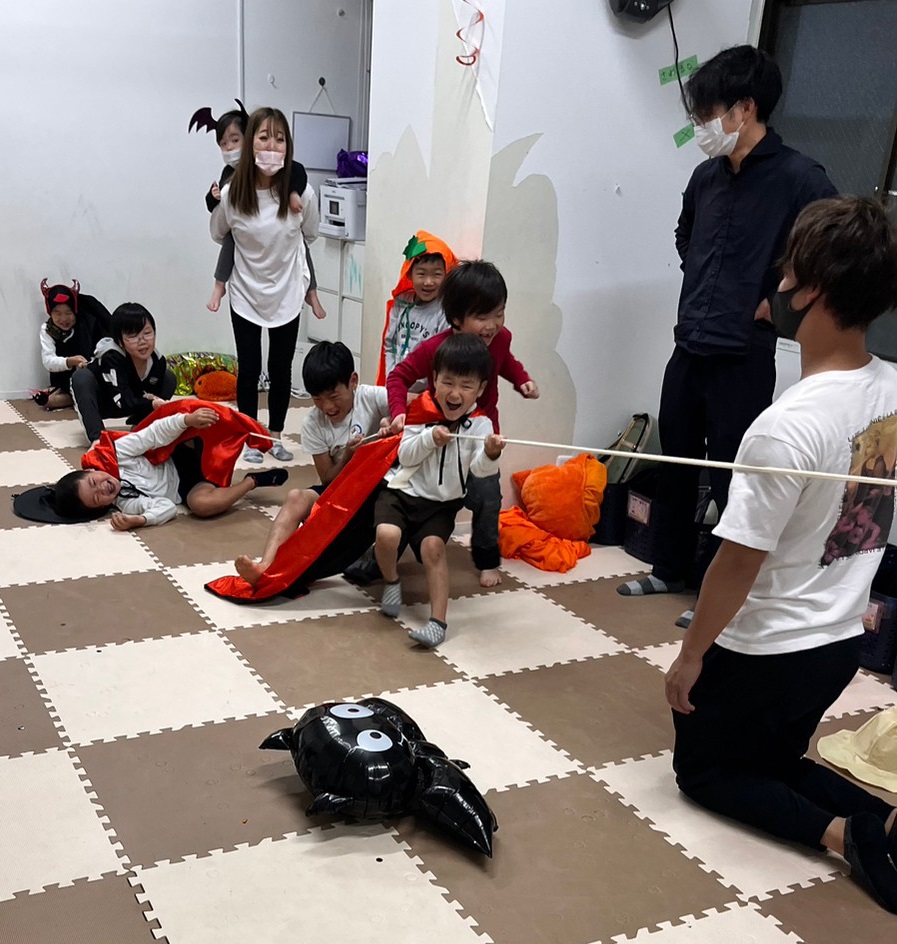 ハロウインイベントで綱引きをする子供たち