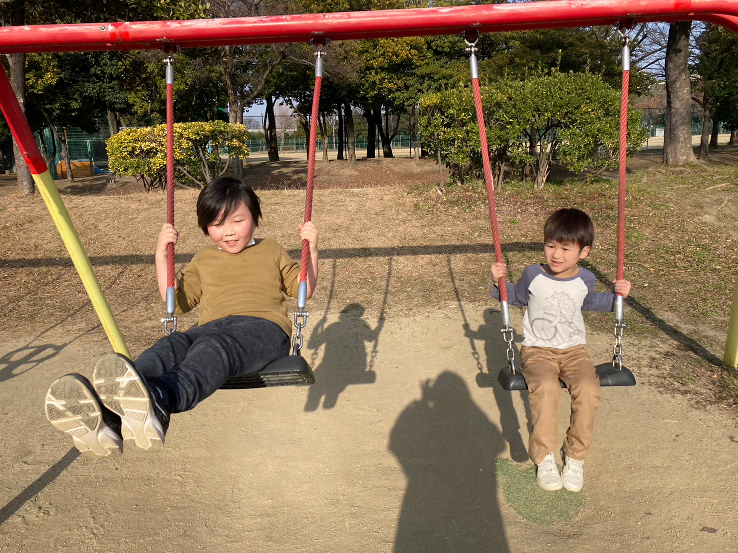 公園のブランコで遊ぶ放課後等デイサービスの児童