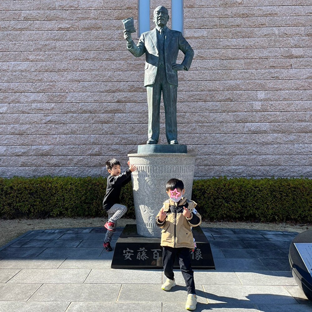 大阪池田のカップヌードルミュージアムの安藤百福像と写真を撮る児童発達支援の子供