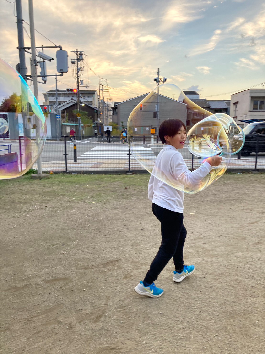 大阪市西成区の旭北公園でシャボン玉遊びをする小学生