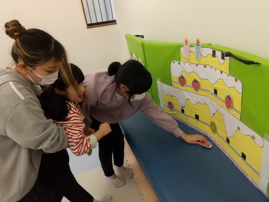 埼玉県所沢市の放課後等デイサービス・児童発達支援事業所、オハナピース新所沢の５月のお誕生日会で、ケーキにイチゴを飾る
様子です。