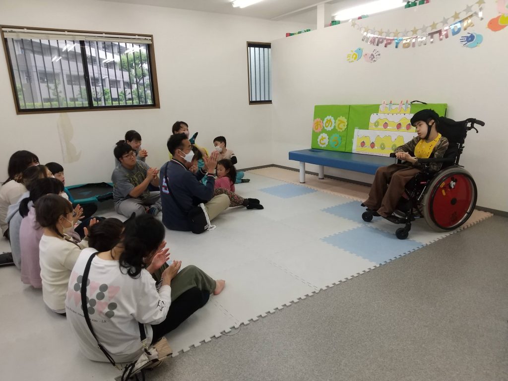 埼玉県所沢市の放課後等デイサービス・児童発達支援事業所、オハナピース新所沢の５月のお誕生日会で、みんなで歌を歌ってお祝いしている様子です。