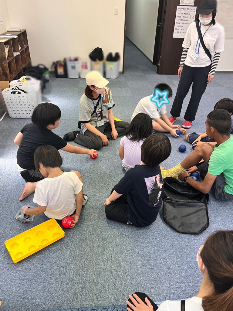 放課後等デイサービス　オハナピース日本橋で　ボッチャの説明を受ける児童。